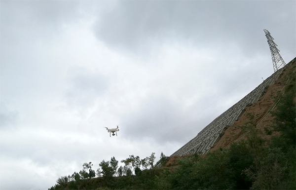 Mit einer Drohne machen die Experten des China Institute of Geo-Environment Monitoring Aufnahmen von einem geotechnisch bereits sanierten Hang.