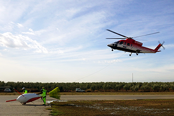 Der BGR-Helikopter beim Start zur Messung der natürlichen Radioaktivität (der NaI-Detektor ist im Helikopter installiert) und der Gradientenmagnetik (SQUID, links im Bild als Schleppkörper)